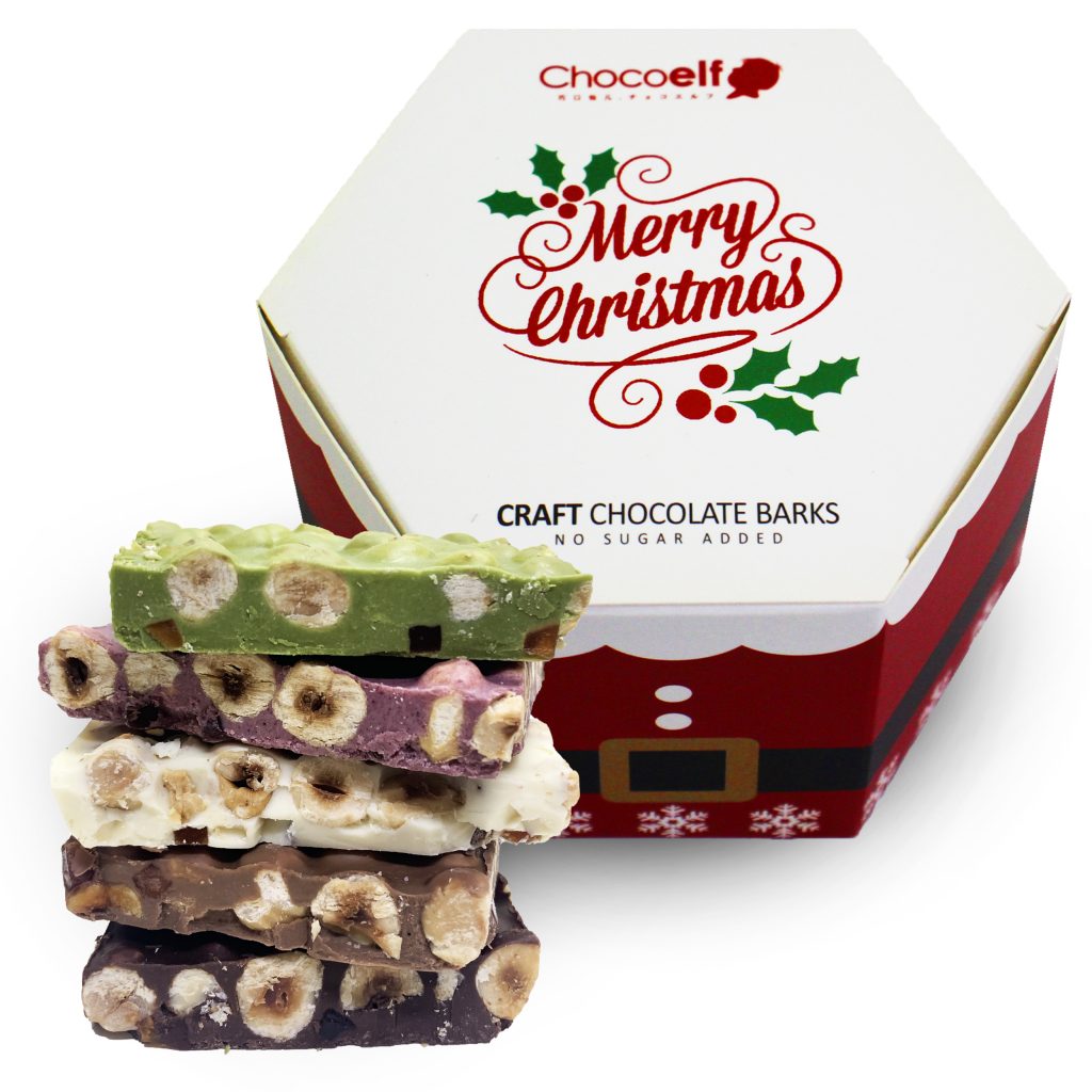 CHOCOELF Christmas chocolate bark with roasted hazelnuts beside its festive box